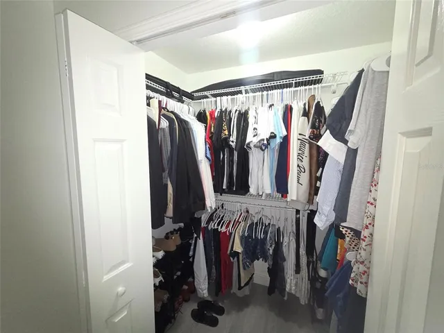 a view of walk in closet with clothes