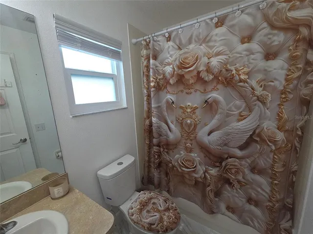 a white toilet sitting next to a shower curtain