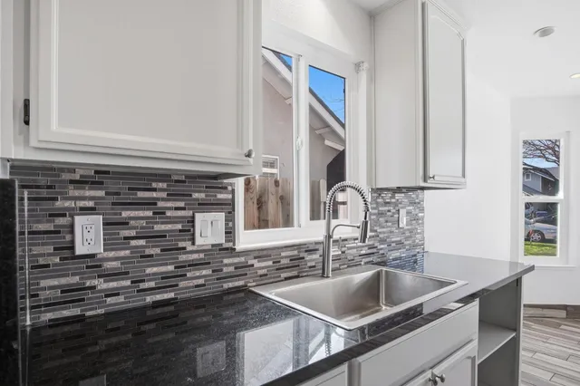a kitchen with granite countertop a sink and a stove
