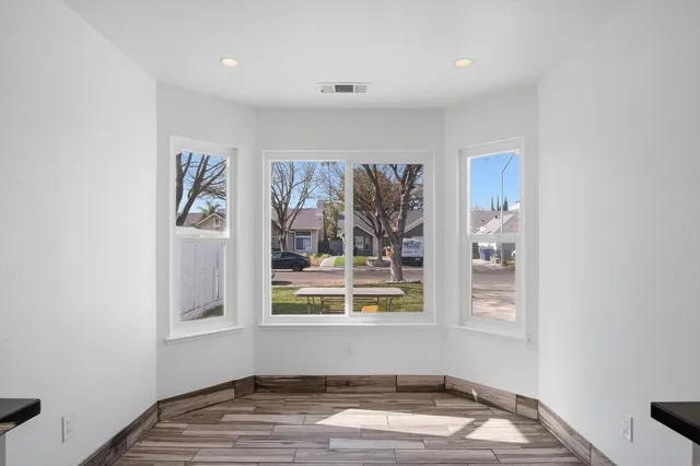 a view of a livingroom with wooden floor and a window