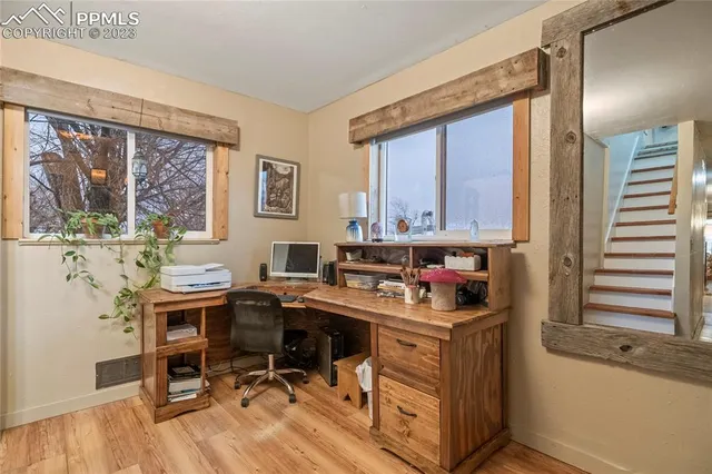 a view of a workspace with furniture and a window