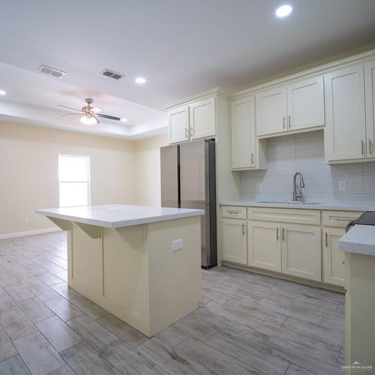 3052 Briggs Road, Unit C Weslaco, TX 78596 - Photo 4 of 16 Modern kitchen featuring light-toned cabinetry, stainless steel refrigerator, white subway tile backsplash, and wood-finish flooring