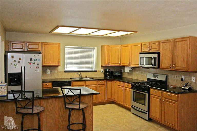1025 Roldan Avenue Simi Valley, CA 93065 - Photo 4 of 28 a kitchen with stainless steel appliances granite countertop a stove a sink dishwasher a refrigerator and cabinets with wooden floor