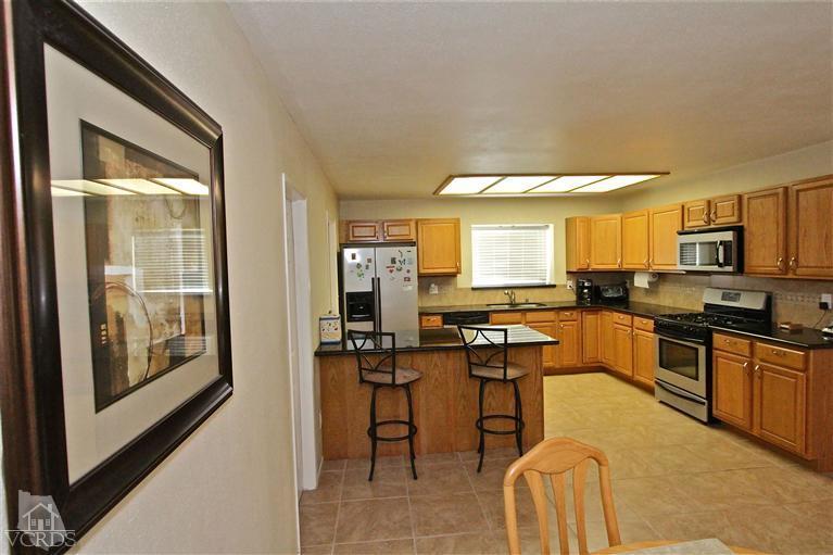 1025 Roldan Avenue Simi Valley, CA 93065 - Photo 6 of 28 a kitchen with stainless steel appliances granite countertop sink stove top oven and cabinets