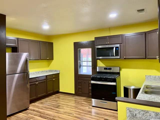 a kitchen with stainless steel appliances a stove a sink and a refrigerator