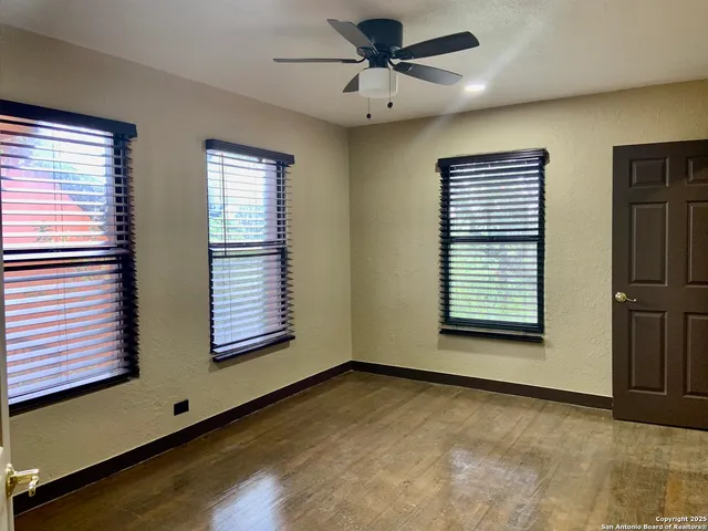a view of an empty room with a window and fireplace