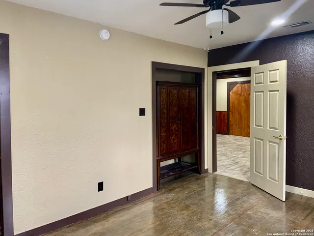 an empty room with closet and a chandelier fan
