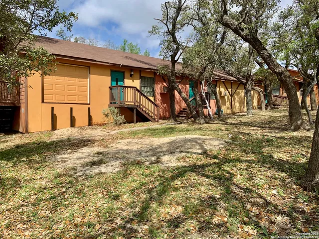 a view of a yard with table and chairs under an umbrella