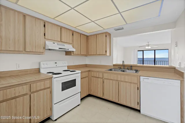a kitchen with granite countertop white cabinets and white appliances