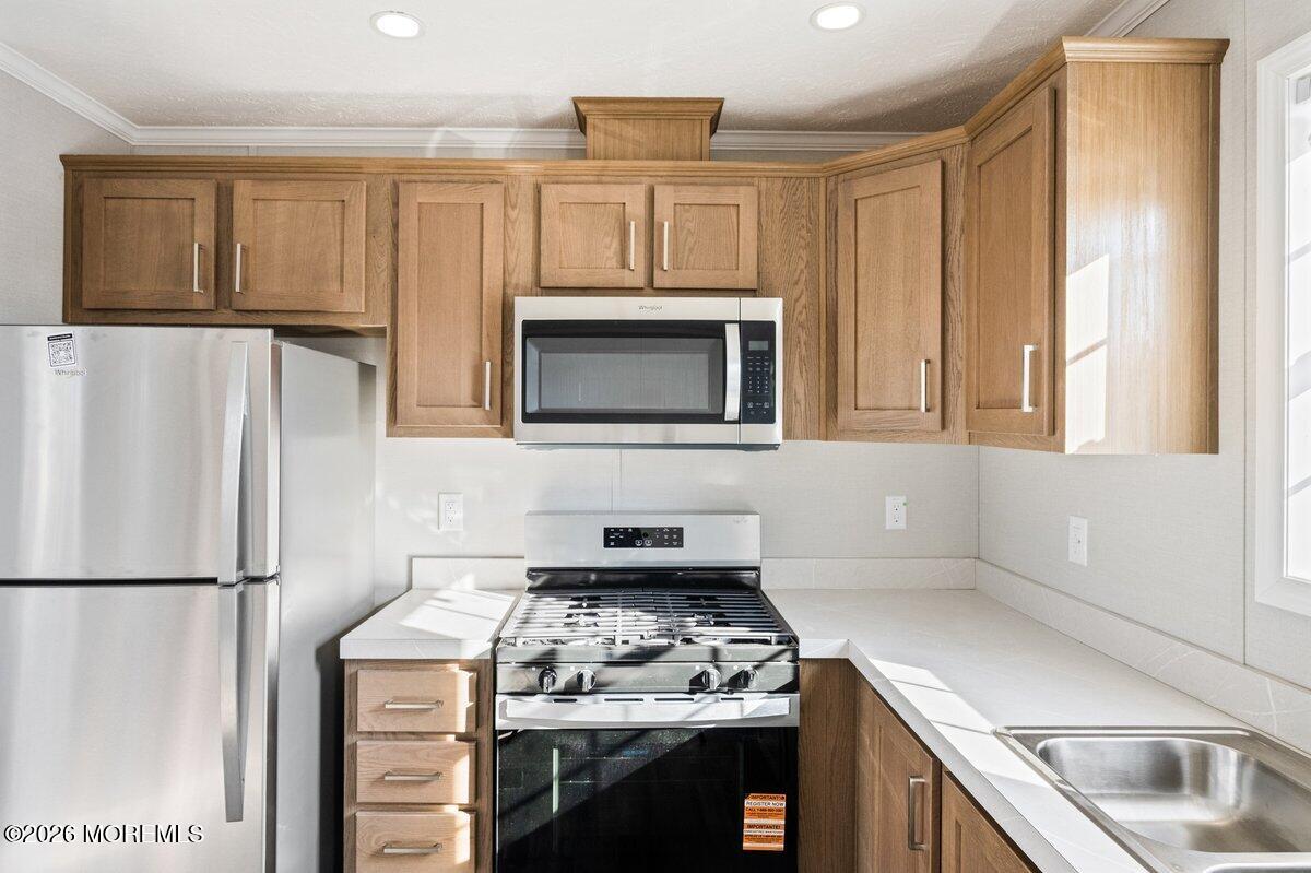 1820 State Rte 35, Unit 16 Wall, NJ 07719 - Photo 10 of 24 a kitchen with stainless steel appliances granite countertop a stove a refrigerator and a microwave