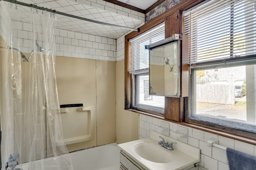 219 Pelham Street Methuen, MA 01844 - Photo 23 of 39 a bathroom with a sink and a large mirror