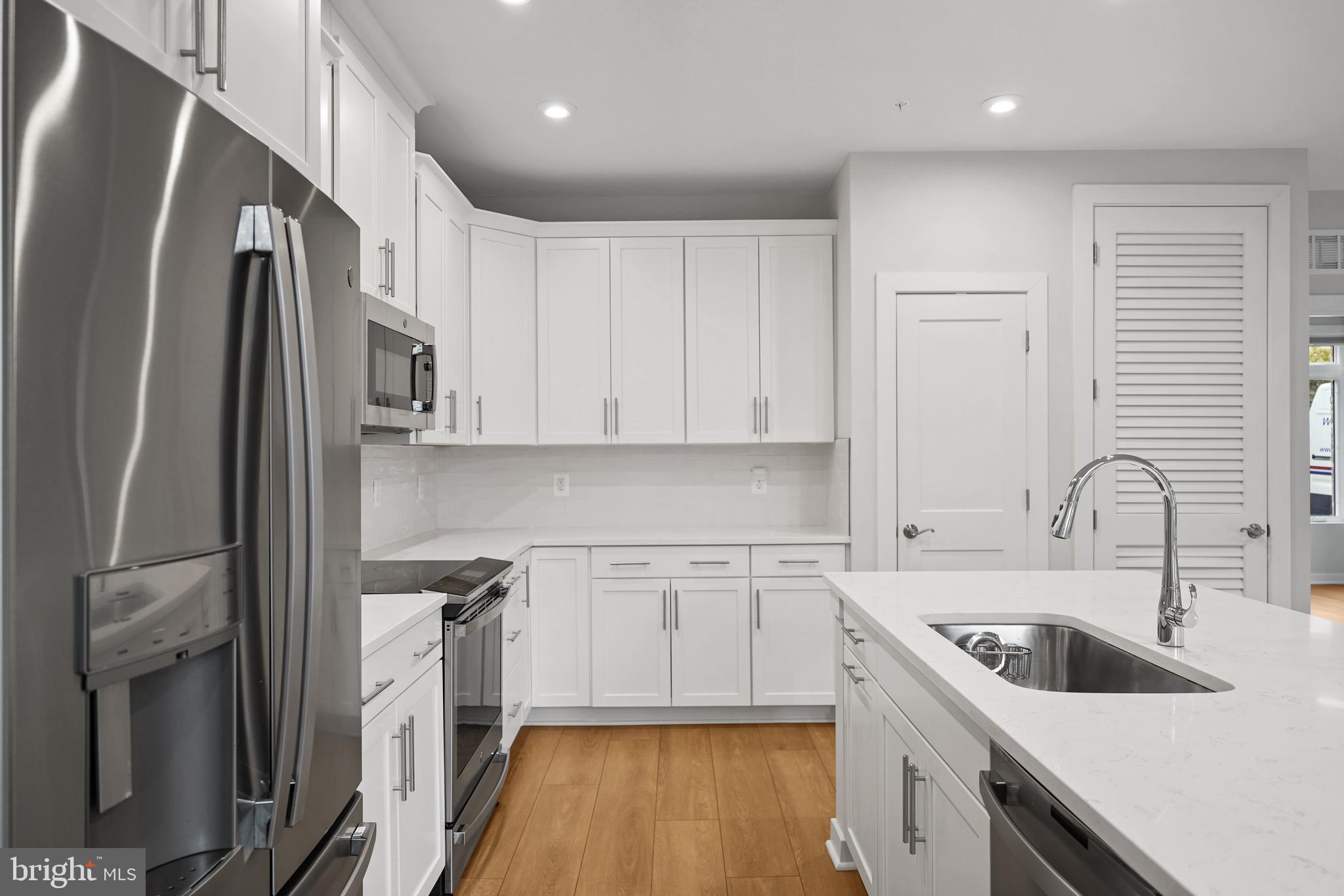 1675 Bandit Loop, Unit 107B Reston, VA 20190 - Photo 7 of 36 a kitchen with white cabinets and refrigerator
