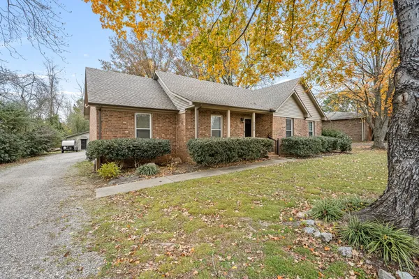 a front view of house with yard and trees around