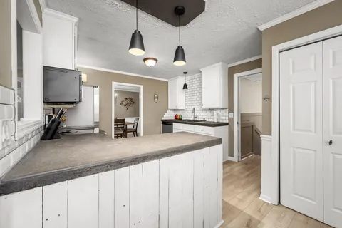 a kitchen with white cabinets and stainless steel appliances