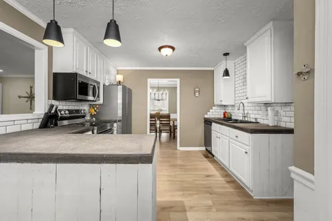 a kitchen with granite countertop a sink and cabinets
