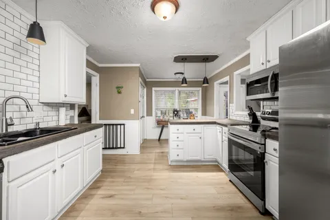 a kitchen with cabinets and wooden floor