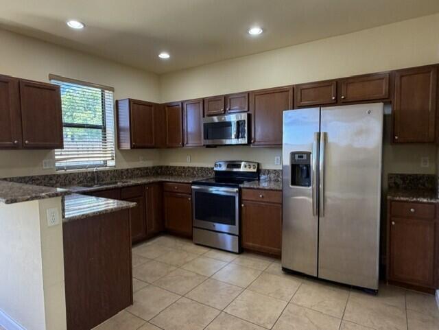 23765 Southwest 118 Avenue, Unit 23765 Homestead, FL 33032 - Photo 6 of 36 a kitchen with stainless steel appliances granite countertop a refrigerator a stove a sink and a microwave