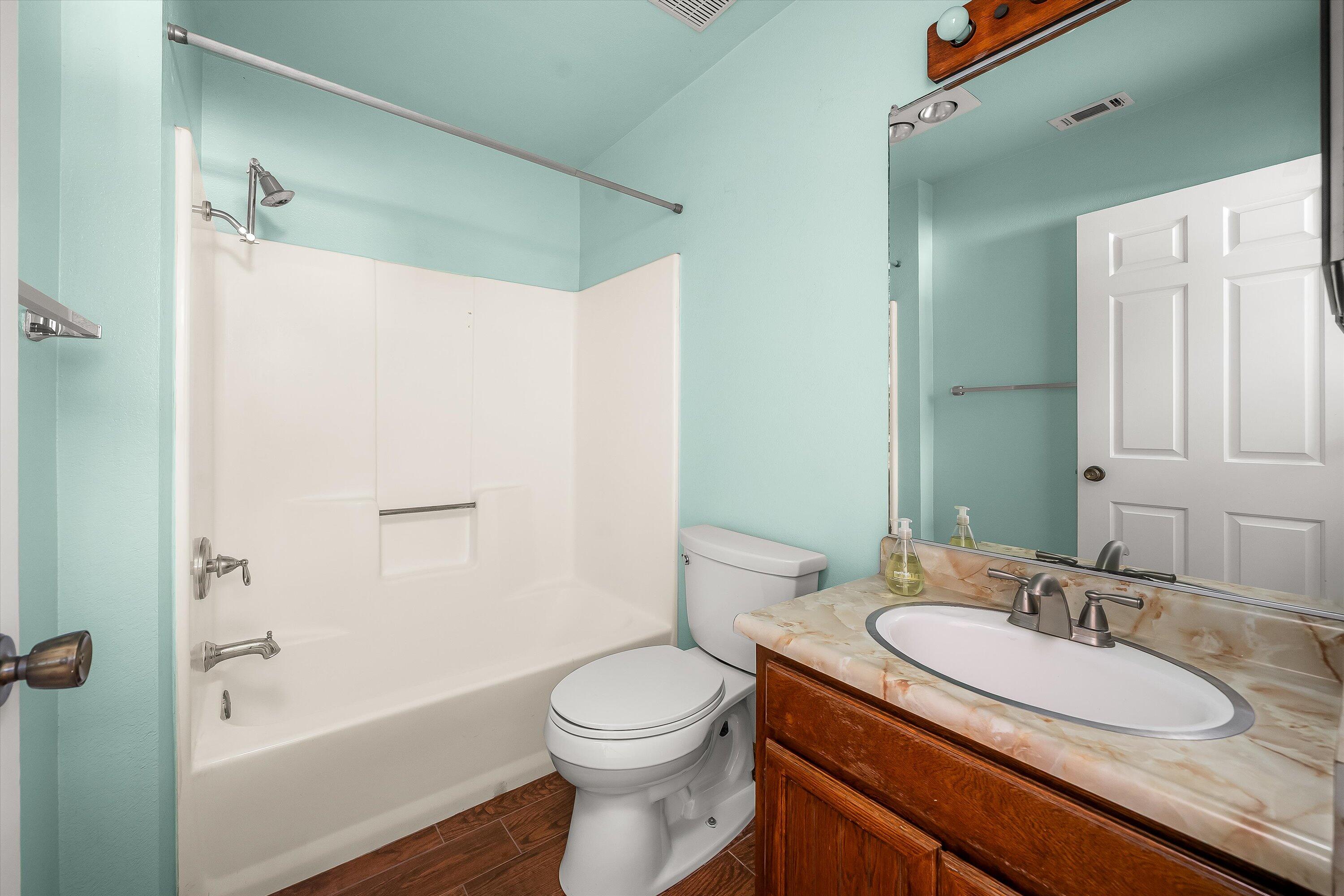 522 West Victoria Street, Unit B Santa Barbara, CA 93101 - Photo 18 of 21 a bathroom with a granite countertop sink toilet a shower and a mirror