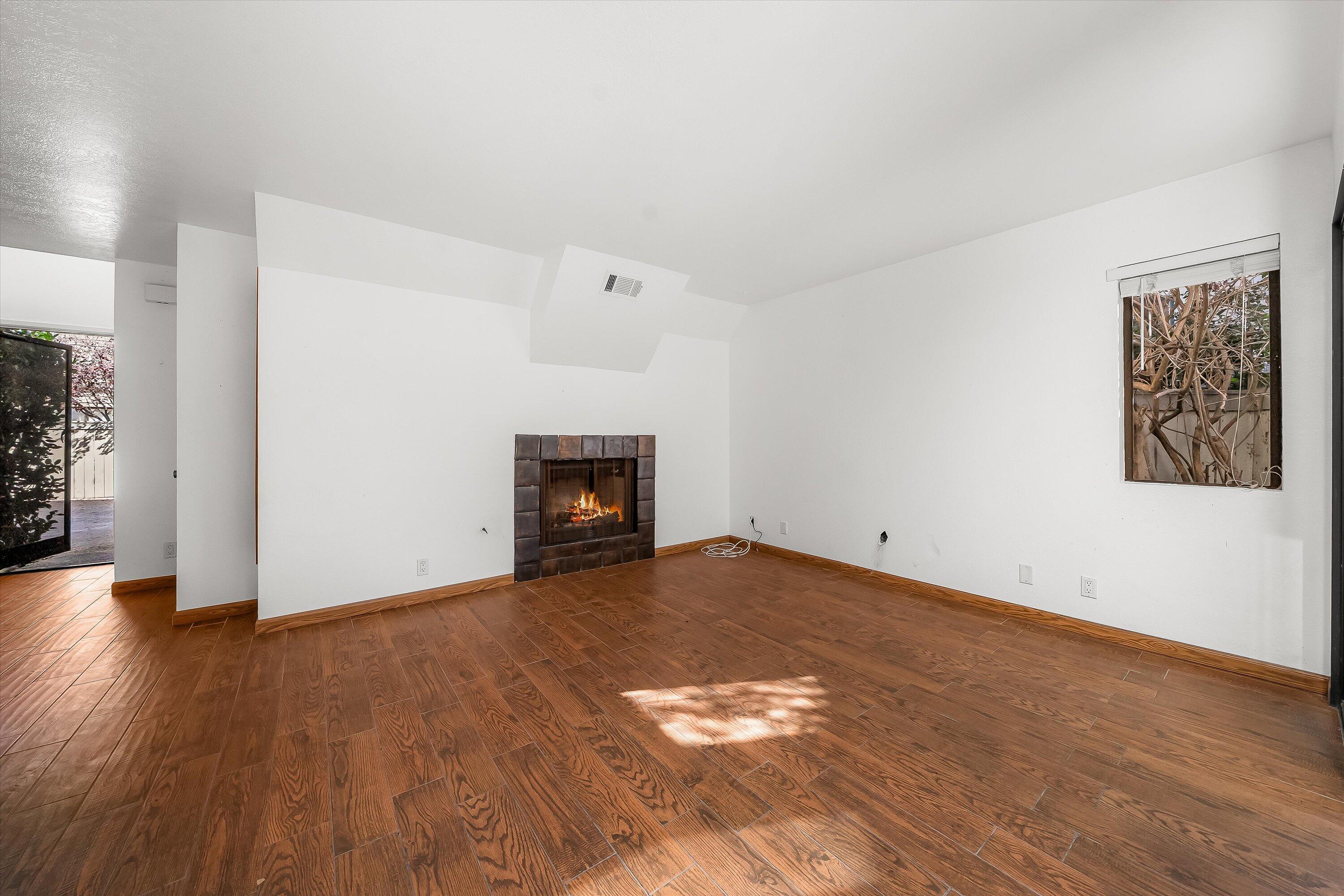 522 West Victoria Street, Unit B Santa Barbara, CA 93101 - Photo 5 of 21 a view of empty room with wooden floor and fireplace
