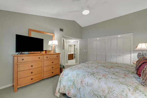 a bedroom with a bed and a flat screen tv in white dresser