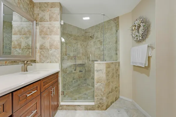 a bathroom with a granite countertop sink a shower and a mirror