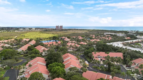 an aerial view of ocean and residential houses with outdoor space