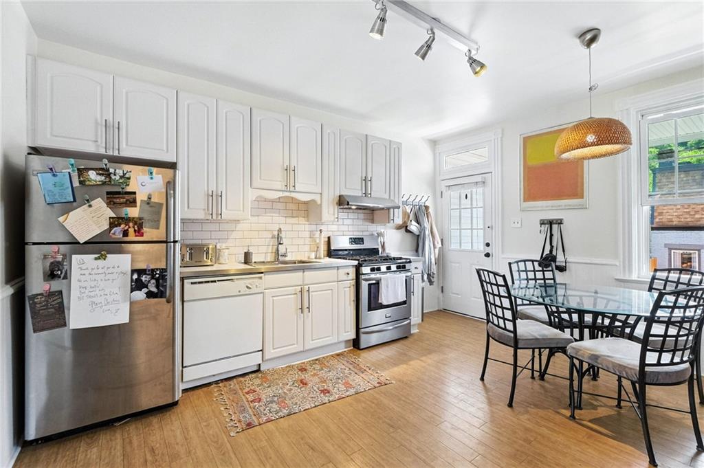 3037 Pulawski Way Pittsburgh, PA 15219 - Photo 5 of 26 a kitchen with stainless steel appliances granite countertop a stove top oven a refrigerator a sink and white cabinets with wooden floor