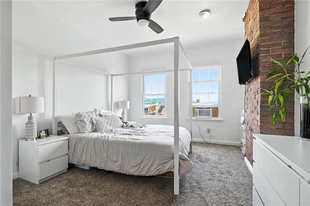 3037 Pulawski Way Pittsburgh, PA 15219 - Photo 8 of 26 a spacious bedroom with a bed couch and a flat tv screen