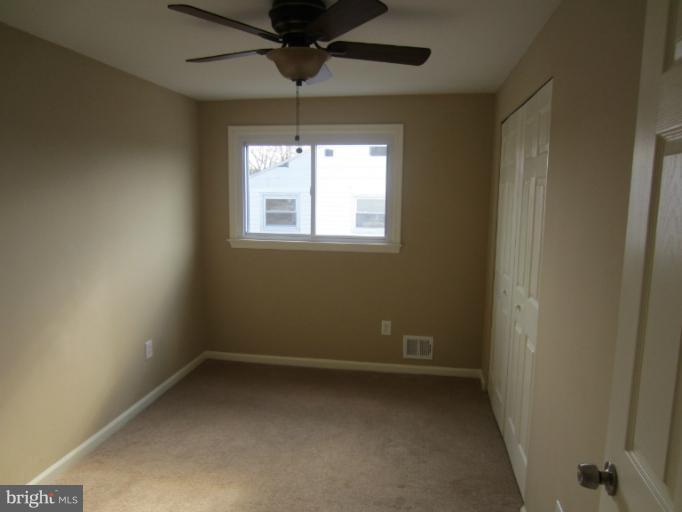 5653 Whitby Road Baltimore, MD 21206 - Photo 22 of 26 en empty room with windows and chandelier fan