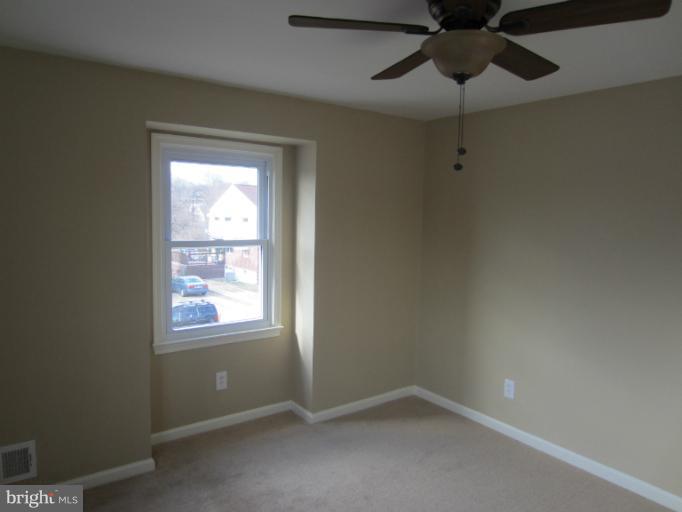 5653 Whitby Road Baltimore, MD 21206 - Photo 4 of 26 an empty room with windows and fan
