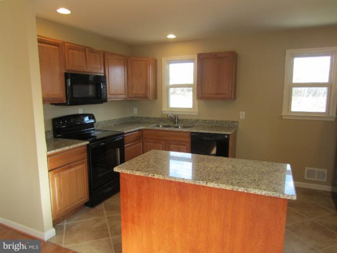 5653 Whitby Road Baltimore, MD 21206 - Photo 10 of 26 a kitchen with granite countertop a sink a stove top oven a counter space and cabinets