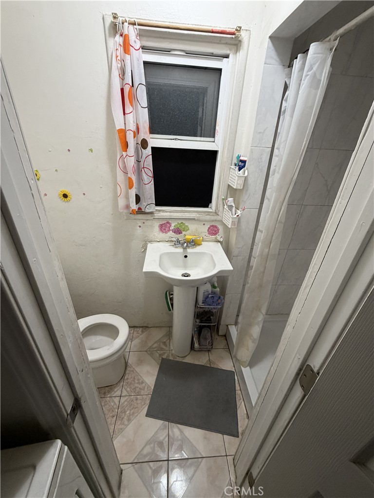 13100 Rangoon Street Arleta, CA 91331 - Photo 13 of 14 a bathroom with a toilet a sink and a mirror