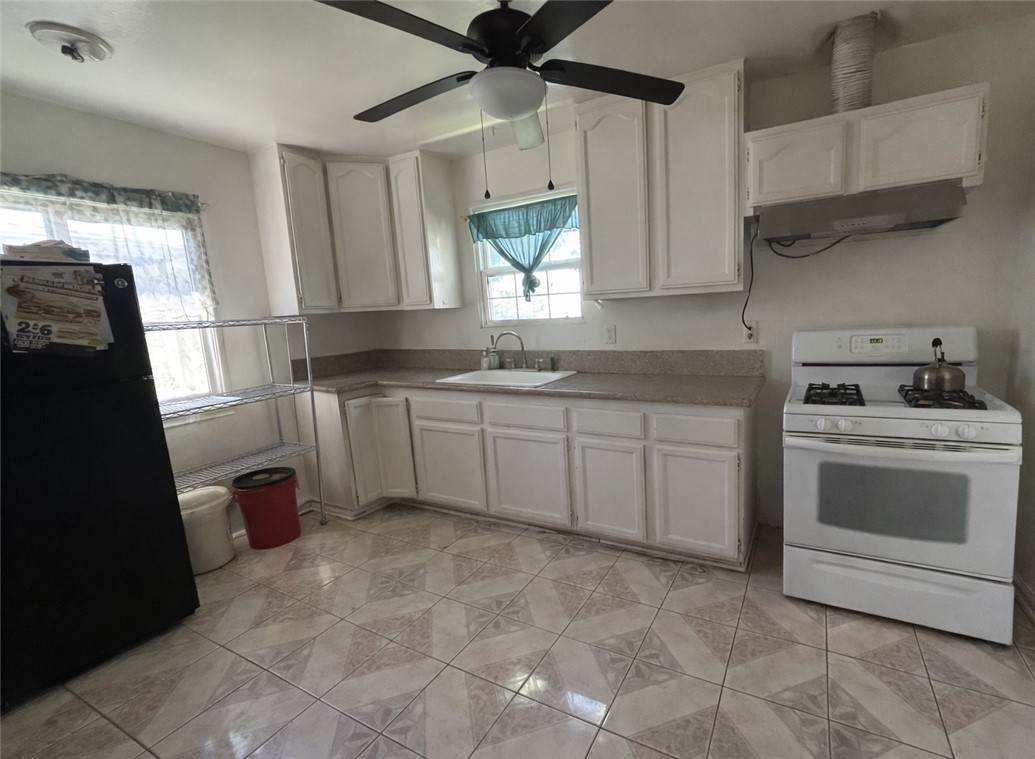 13100 Rangoon Street Arleta, CA 91331 - Photo 5 of 14 a kitchen with a sink stove and cabinets