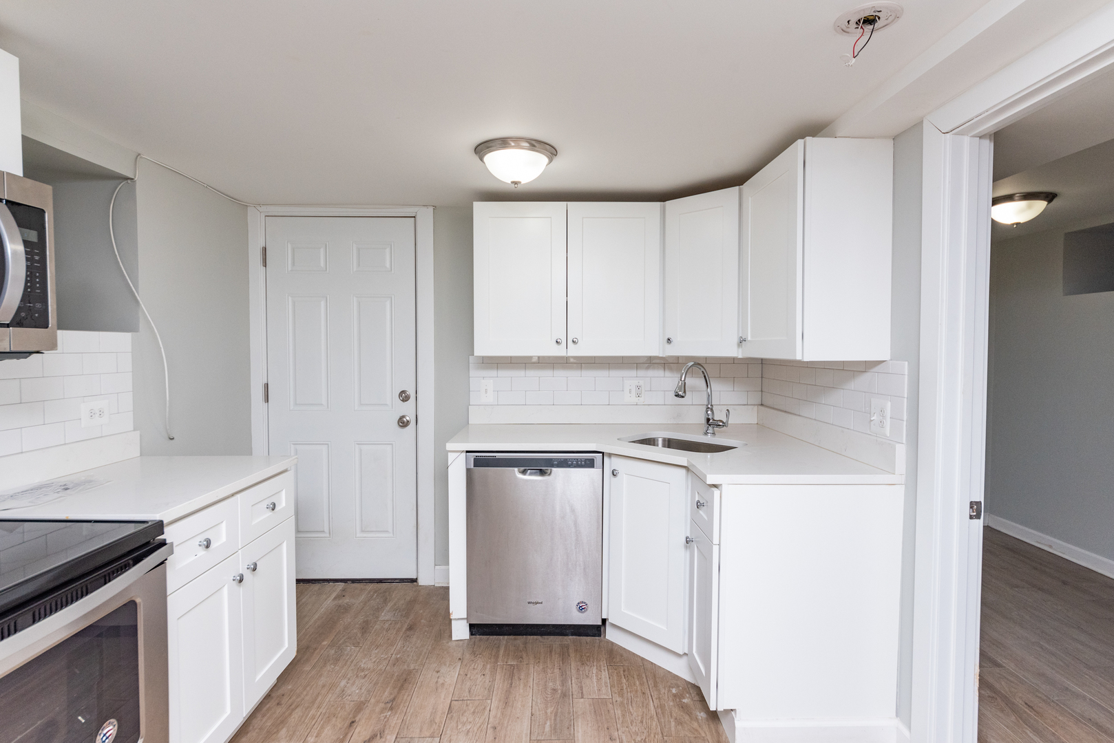 1431 West Flournoy Street, Unit G Chicago, IL 60607 - Photo 3 of 12 a kitchen with stainless steel appliances granite countertop a sink and cabinets with wooden floor