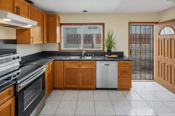 a kitchen with stainless steel appliances granite countertop a stove a sink and a microwave