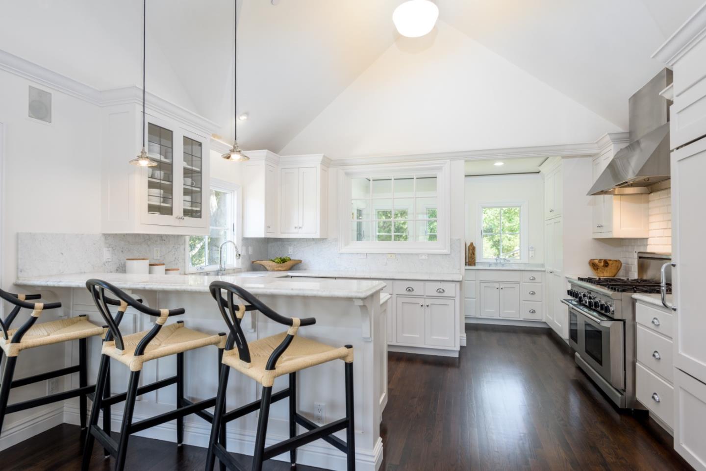 1075 Godetia Drive Woodside, CA 94062 - Photo 9 of 33 a kitchen with stainless steel appliances a table chairs sink and cabinets