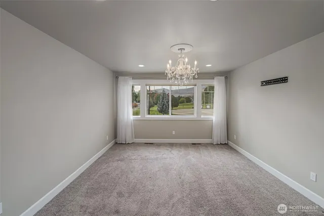 en empty room with windows and chandelier