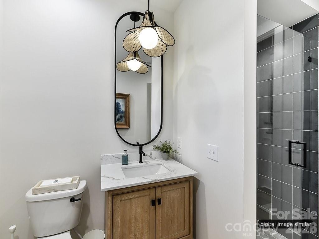 1002 Kingbird Lane, Unit 7 Clover, SC 29710 - Photo 32 of 40 a bathroom with a granite countertop toilet sink and mirror