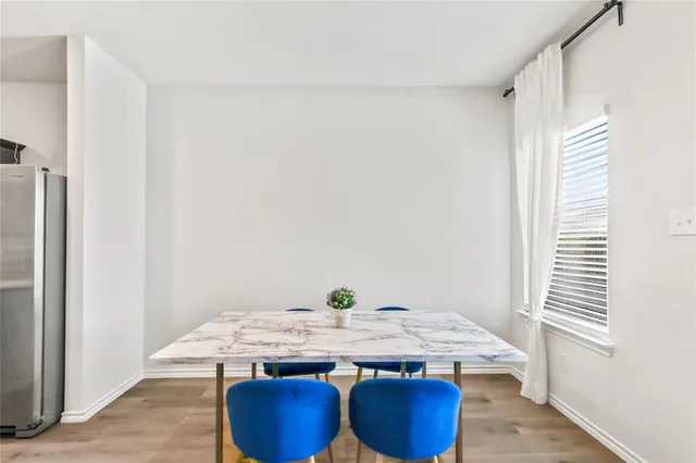 a dining table with chairs and window