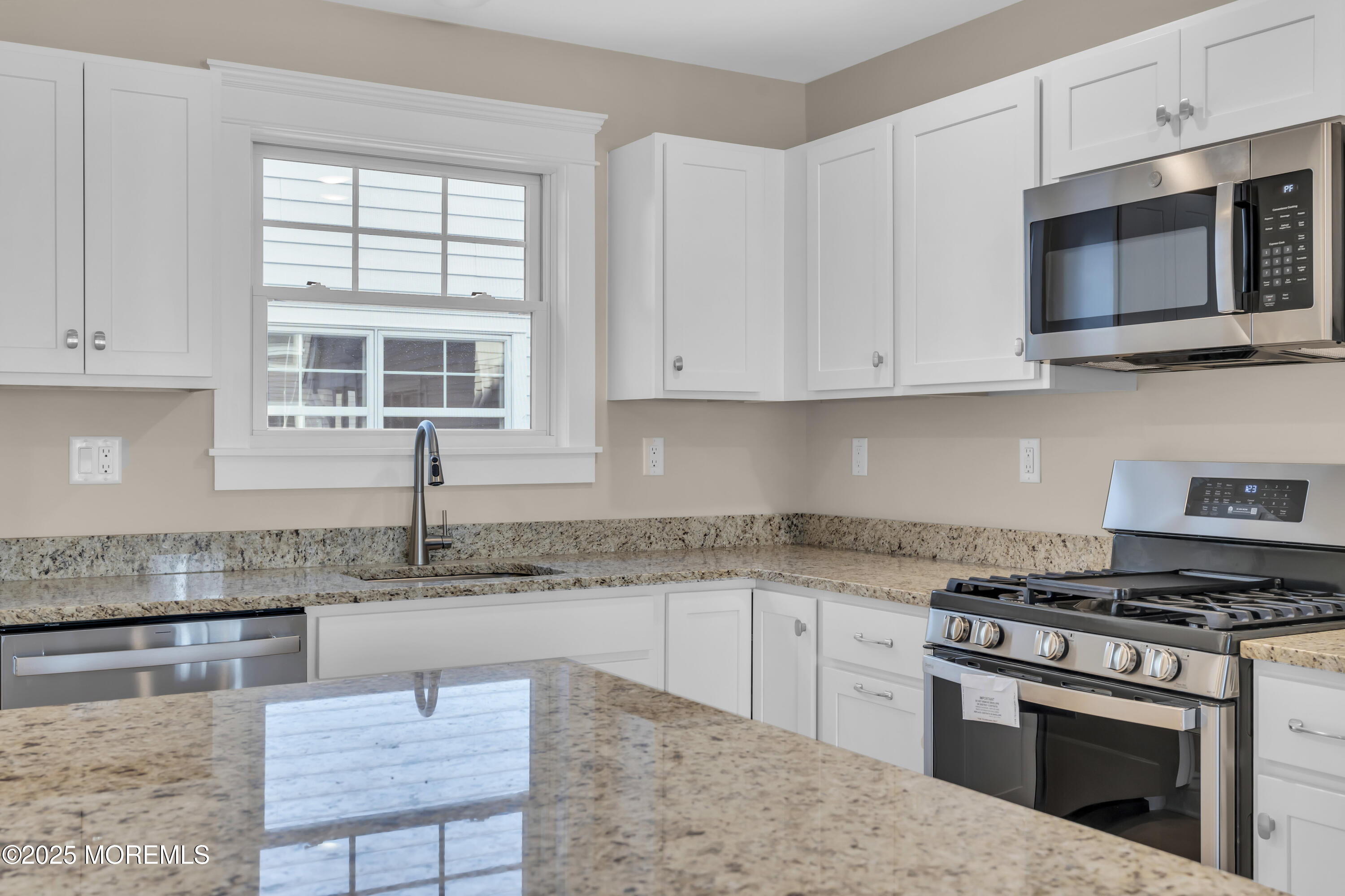 24 Shell Road, Unit 126 Mantoloking, NJ 08738 - Photo 11 of 31 a kitchen with granite countertop a sink and a stove top oven
