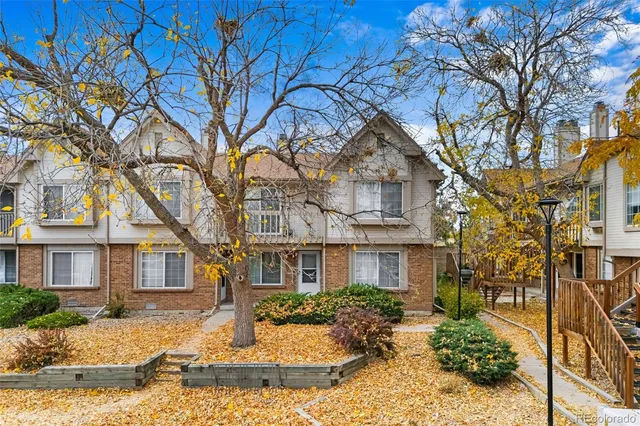 a front view of a residential houses with yard and trees