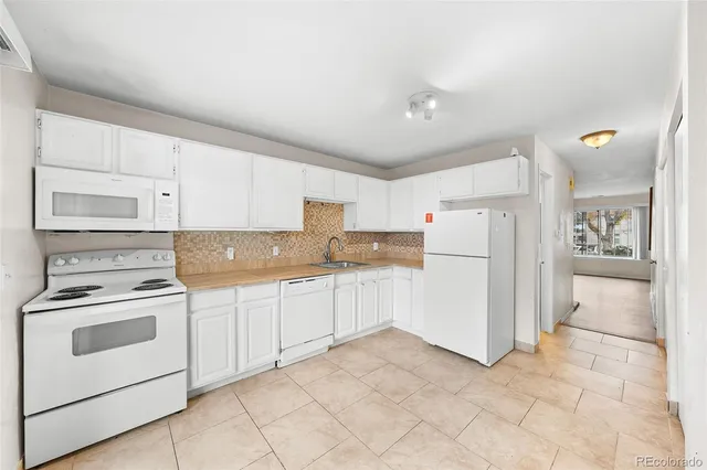 a kitchen with a stove top oven and refrigerator