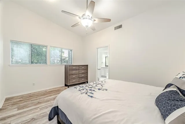 a bedroom with a large bed and a chandelier