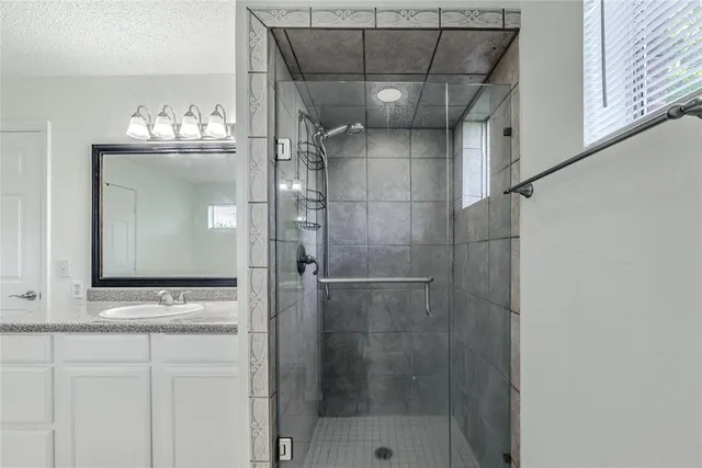 a bathroom with a mirror and a shower