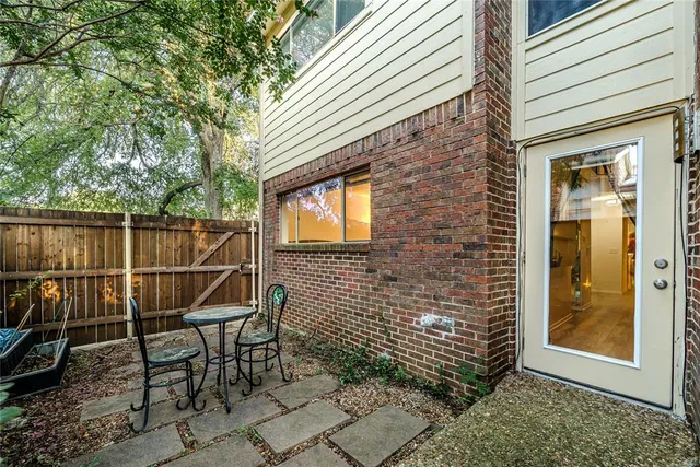 a patio with table and chairs and potted plants