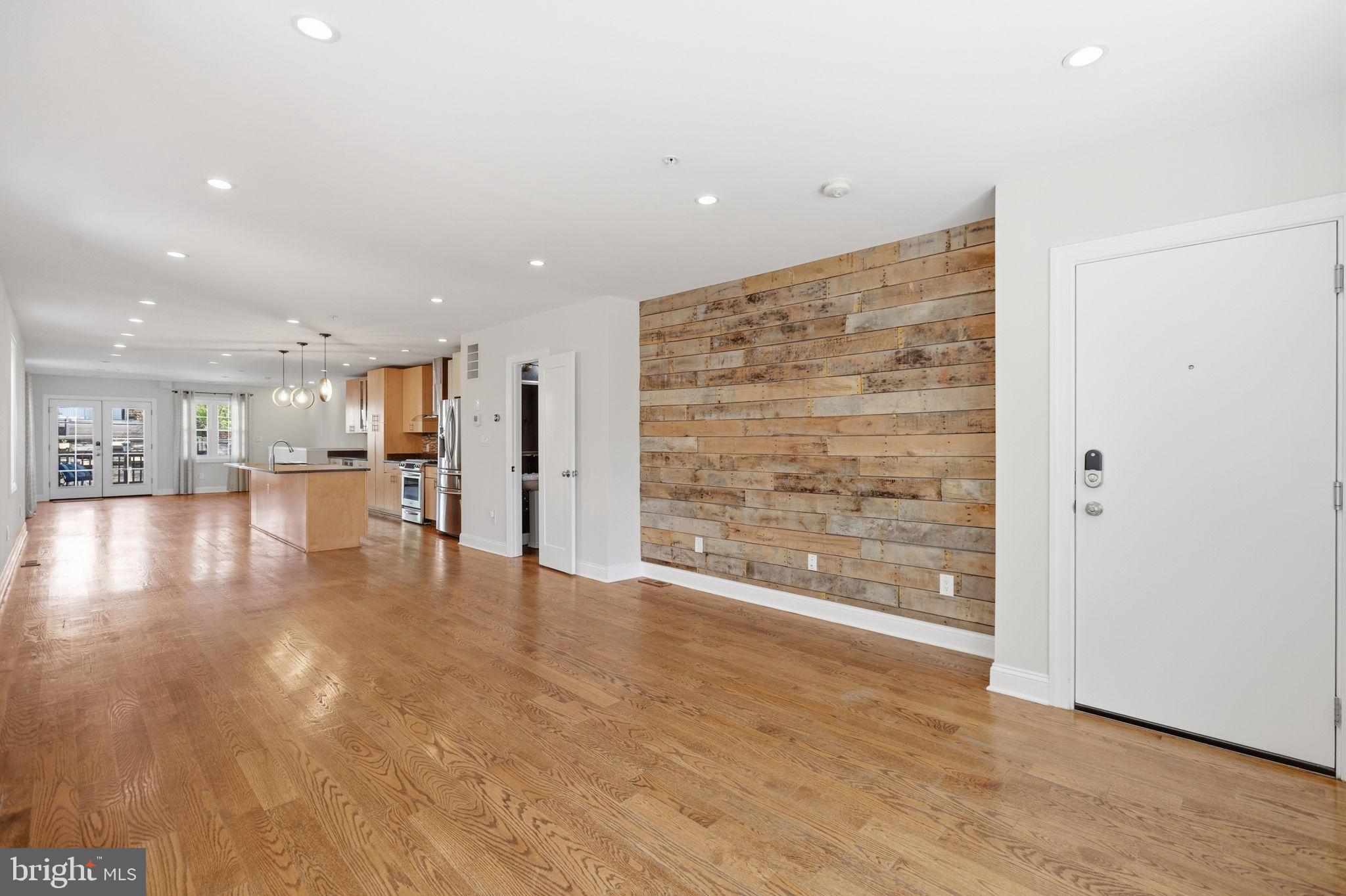 1820 Independence Avenue Southeast, Unit 1 Washington, DC 20003 - Photo 6 of 32 a view of an empty room with wooden floor and a kitchen