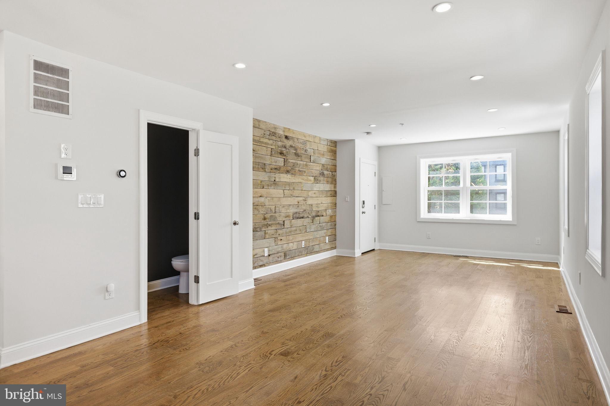 1820 Independence Avenue Southeast, Unit 1 Washington, DC 20003 - Photo 7 of 32 an empty room with wooden floor and windows
