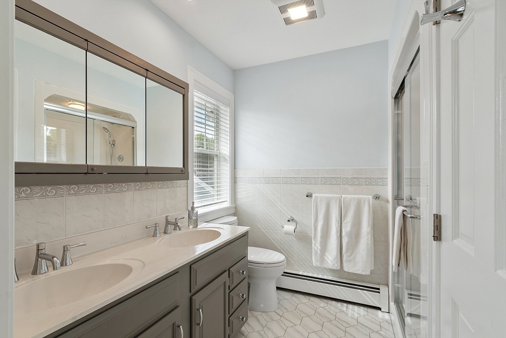1 Colonial Road Lynnfield, MA 01940 - Photo 27 of 42 a bathroom with a sink a toilet and a mirror