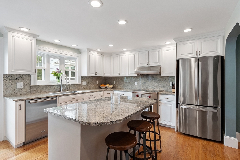 1 Colonial Road Lynnfield, MA 01940 - Photo 10 of 42 a kitchen with stainless steel appliances granite countertop a sink a stove a refrigerator and island with wooden floor
