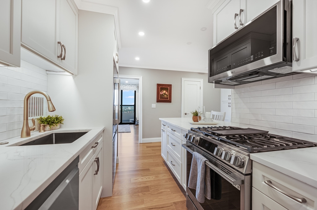 85 East India Row, Unit 34G Boston, MA 02110 - Photo 8 of 20 a kitchen with stainless steel appliances granite countertop a stove and a microwave